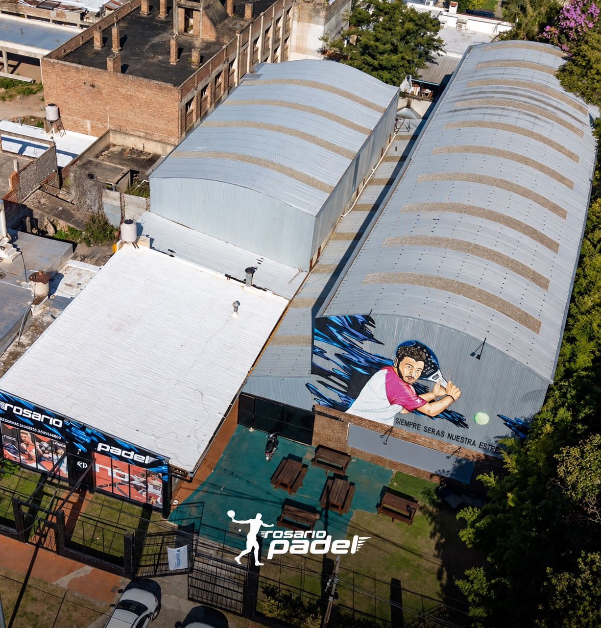 Vista aérea de Rosario Padel, con sus techos, el mural y las mesas del patio
